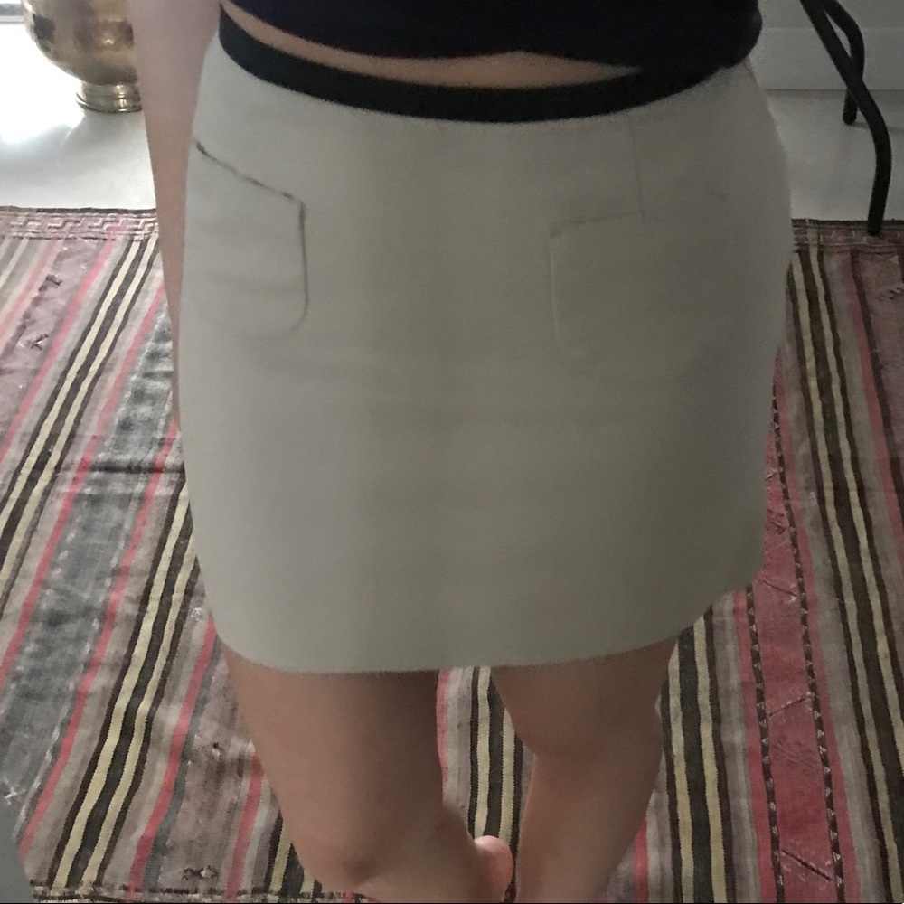 Creme coloured mini skirt with black trim on waist